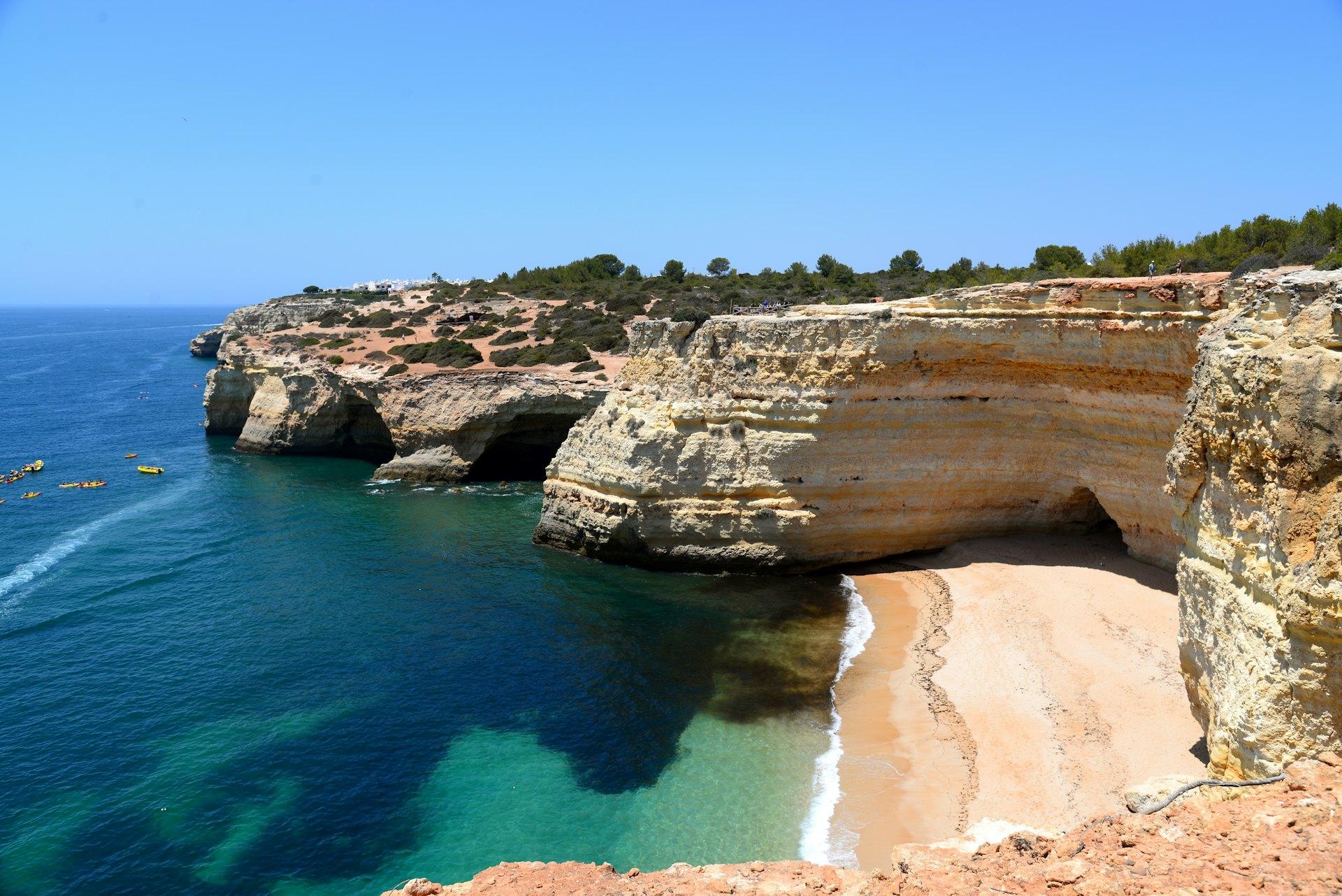 Sandy cove beneath limestone cliffs in the Algarve