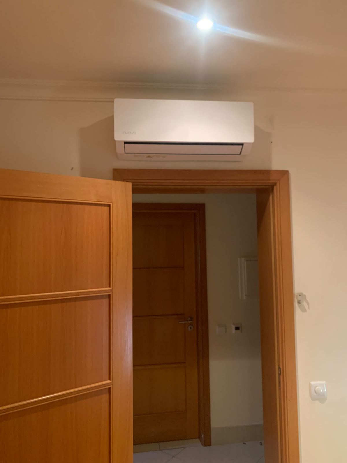 Nuova indoor unit above a doorway